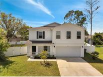 Charming two-story home featuring a well-maintained lawn, white picket fence and attached two car garage at 815 Savona Pl, Kissimmee, FL 34758