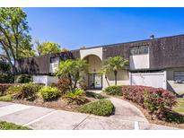 Attractive condo exterior with mature landscaping, an arched entryway, and a peaked roof at 1120 Portland Ave # 2, Orlando, FL 32803