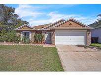 Charming single-story home with a well-maintained lawn, brick accents, and a two-car garage at 2215 Mallard Creek Cir, Kissimmee, FL 34743