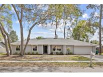 Charming single-story home with a well-manicured lawn, mature trees and attached garage at 321 Ferdinand Dr, Longwood, FL 32750