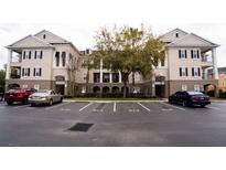 Exterior view of a multi-story condo building with well-manicured landscaping and ample parking spaces at 3605 Conroy Rd # 537, Orlando, FL 32839