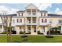 Charming three-story townhome with balconies, red shutters, and a well-manicured lawn at 378 Blue Bayou Ln, Winter Springs, FL 32708