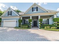 Charming one-story home featuring a beautiful front yard, decorative landscaping, and a brick-paved driveway at 5215 Phillips Oaks Ln, Orlando, FL 32812