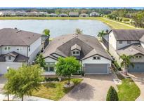 Beautiful lake view home with brick driveway, well-manicured lawn, and attached two-car garage at 5647 Barletta Dr, St Cloud, FL 34771