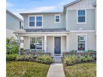 Charming two-story home featuring a well-manicured lawn, gray door and blue siding at 1312 Painted Bunting Ave, Winter Garden, FL 34787
