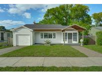 Charming single-story home featuring a well-manicured lawn, covered front porch, and attached garage at 1407 E Kaley St, Orlando, FL 32806