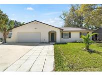 Charming single-story home with a well-maintained lawn, attached garage and inviting walkway at 1505 Guinevere Dr, Casselberry, FL 32707