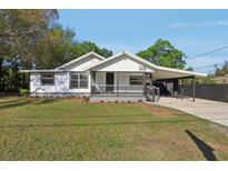 Charming single-story home with a covered porch, carport, and well-maintained front yard at 1518 Coletta Dr, Orlando, FL 32807