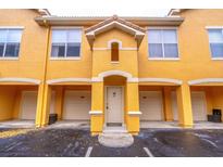 Inviting condo with a yellow painted facade, covered entry, and personal single car garage at 19920 Villa Ridge Dr # 206, Orlando, FL 32821