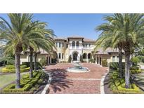 Stunning Mediterranean-style home featuring a fountain, lush landscaping, and a circular driveway at 3402 Cocard Ct, Windermere, FL 34786