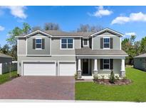 Charming two-story home featuring a manicured lawn and a brick driveway leading to a two-car garage at 3418 Douglas Fir Dr, Apopka, FL 32703