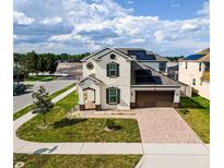 Beautiful two-story home with a well-manicured lawn, brick driveway, and solar panels at 5201 Villa Rosa Ave, St Cloud, FL 34771