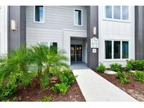 Modern building exterior featuring a walkway, well manicured landscaping, and a clearly visible address at 7740 Sandy Ridge Dr # 136, Reunion, FL 34747