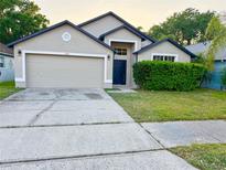 Inviting single-story home showcasing a two-car garage and a neatly manicured lawn at 1028 Henson Ct, Oviedo, FL 32765