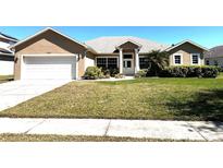 Charming single-story home with a well-manicured lawn, a two car garage and beautiful landscaping at 10912 Smokey Ridge Ct, Clermont, FL 34711