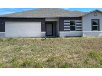 Charming single-story home features a two-car garage and modern gray and white color scheme at 1209 Atlantic Way, Kissimmee, FL 34759