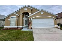 Inviting single-story home with a manicured lawn, attached garage, and an arched entryway at 12526 Ringwood Ave, Orlando, FL 32837