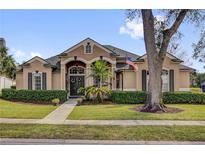 Charming single-story home featuring a manicured lawn, decorative shutters, and a welcoming entryway at 1415 Crocus Ct, Longwood, FL 32750