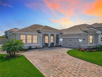 Charming single-story home with a brick driveway, well-manicured lawn, and a two-car garage at 16084 Black Hickory Dr, Winter Garden, FL 34787