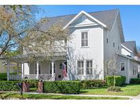 Charming two-story home with a covered front porch, manicured landscaping, and classic architectural details at 2090 Common Way Rd, Orlando, FL 32814