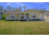 Charming single-story home featuring a well-maintained lawn, attached garage, and inviting facade at 260 La Paz Dr, Kissimmee, FL 34743