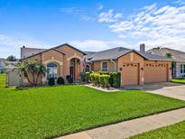 Charming single-story home with well-manicured lawn, inviting front door and a three car garage at 3710 Ahoya Ln, Orlando, FL 32837