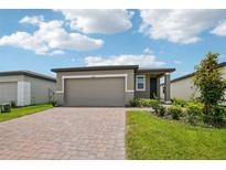 Charming single-story home featuring a paver driveway and beautiful landscaping in the front yard at 4006 Copperleaf Ln, Poinciana, FL 34759