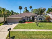 Charming single-story home boasts a well-manicured lawn, beautiful landscaping, and a classic stucco facade at 712 Timberwilde Ave, Winter Springs, FL 32708