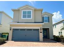 Two-story home with a brick driveway and an attached two-car garage at 7417 Marker Ave, Kissimmee, FL 34747