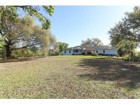 Sprawling one-story home with mature trees and a well-maintained lawn at 7435 Redwing Rd, Groveland, FL 34736