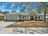 Charming single-story home featuring a two-car garage, manicured lawn, and inviting front porch at 1137 Stratton Ave, Groveland, FL 34736