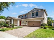 Beautiful two-story home featuring a two-car garage, brick driveway and lush landscaping at 11926 Verrazano Dr, Orlando, FL 32836