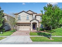 Charming two-story home featuring a well-manicured lawn, stone accents, and a two-car garage at 1400 Moon Valley Dr, Davenport, FL 33896