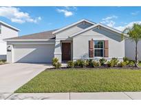 Charming single-story home featuring a well-manicured lawn and an attached two-car garage at 26101 Bristleleaf Ct, Leesburg, FL 34748