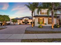 Stunning two-story home with a brick driveway, elegant landscaping, and charming exterior shutters at 2680 Lookout Ln, Kissimmee, FL 34746