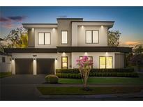 Contemporary two-story home with a two-car garage and manicured landscaping at twilight at 3322 Helen Ave, Orlando, FL 32804