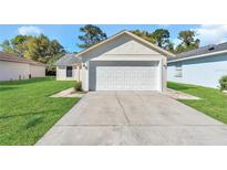 Front exterior of the home featuring a two car garage and a concrete driveway at 4008 Natchez Trace Dr, St Cloud, FL 34769