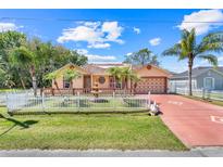 Charming single-Gathering home with well-manicured lawn, fountain, palms, and a white picket fence at 449 Martigues Drive, Kissimmee, FL 34759