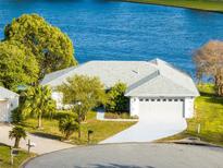 Beautiful single-story home with a two-car garage and a well-manicured lawn next to a gorgeous lake at 5404 E Sacramento Ct, Orlando, FL 32821