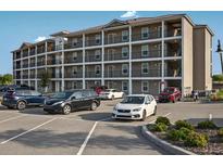 Multi-level tan building with multiple balconies and parking lot in front at 831 Retreat Blvd # 103, Davenport, FL 33897