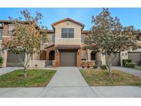 Charming townhome featuring a two-car garage and well-manicured landscaping for a welcoming curb appeal at 9620 Doris Ln, Orlando, FL 32829