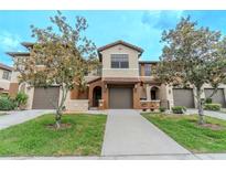 Charming townhome showcasing a well-manicured lawn and neutral-toned exterior, complemented by lovely trees at 9620 Doris Ln, Orlando, FL 32829