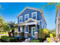 Charming two-story home with a welcoming porch, well-manicured landscaping, and a bright blue exterior at 11880 Sonnet Ave, Orlando, FL 32832