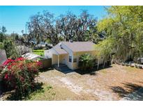 Quaint single-story home featuring lush trees, and a charming front porch, perfect for enjoying the outdoors at 1503 Holly Rd, Lakeland, FL 33801