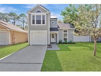 Charming two-story home with light grey siding, well-manicured lawn, and attached garage at 155 Aunt Polly Ct, Orlando, FL 32828