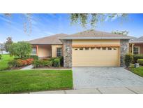 Charming single-story home with stone accents, manicured lawn, and well-kept landscaping at 253 Lake Cassidy Dr, Kissimmee, FL 34759