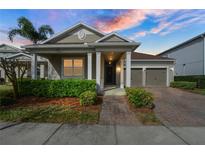 Charming home exterior with a two-car garage, brick driveway and walkway, and well-maintained landscaping at 3242 Irish Peach Dr, Winter Garden, FL 34787