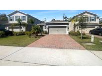 Charming single-story home featuring a brick driveway, attached garage, and well-maintained landscaping at 3882 Crawley Down Loop, Sanford, FL 32773