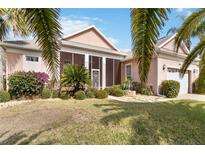 Charming single-story home featuring a screened porch, lush landscaping, and a well-maintained lawn at 4724 Sable Ridge Ct, Leesburg, FL 34748