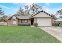 Charming single-story brick home with a well-manicured lawn and two-car garage at 5444 Lighthouse Rd, Orlando, FL 32808